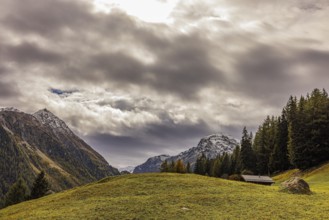 Dark clouds over an alpine meadow above Grimentz, in the background the mountain peaks of Corne de