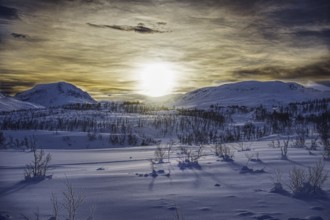 Snowy mountain landscape at sunrise with long shadows, Norway, Europe