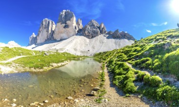Breathtaking panorama of tre cime di lavaredo reflecting in a crystal clear alpine lake, surrounded