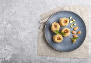 Kunafa, traditional arabic sweets in blue ceramic plate on a gray concrete background. top view,