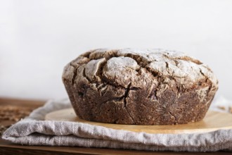 Yeast free homemade bread with whole rye and wheat grains on rustic wooden background. close up