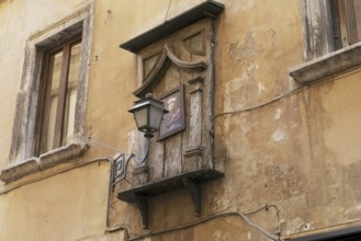 Madonna painting with a lantern in front on a house in the historic centre of Rome, Italy, Europe