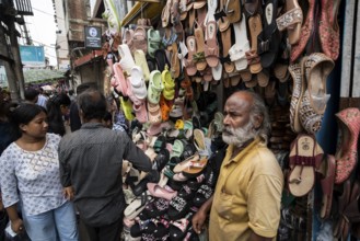 A vendor sells shoes and sandals at a street market ahead of Durga Puja festival on October 7, 2024