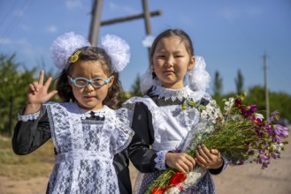 Schoolgirl with a bouquet of flowers on her first day at school, Issyk-Kul region, Kyrgyzstan, Asia