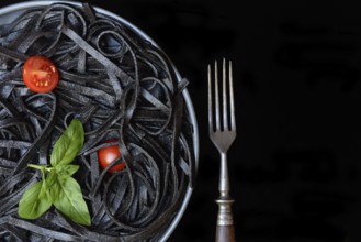 Black pasta coloured with squid ink and fork, Taglioni al Nero di Seppia, Italy, Europe