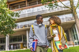 Multiethnic students walking out the university campus in a sunny day of autumn