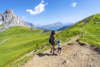Mother and son enjoying the scenic view of the giau pass in the italian dolomites during a summer