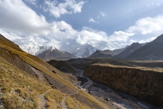 Valley with river Achik Tash between high mountains, mountain landscape with glaciated peak Pik