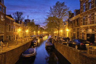 Typical Netherlands city view, canal with boats and houses illuminated in the evening. Haarlem,