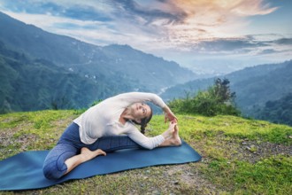 Yoga outdoors, young sporty fit woman doing Hatha Yoga asana parivritta janu sirsasana, Revolved