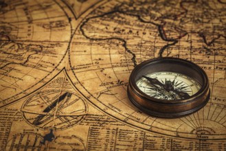 Travel geography navigation concept background, old vintage retro compass on ancient world map