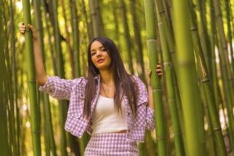 Young caucasian girl with a pink skirt in a bamboo forest. Enjoying the city on summer vacation in