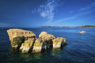 White rocks of famous tourist attraction of Milos island Sarakiniko beach and yacht boat at