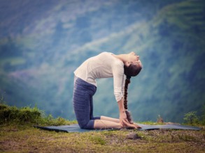 Yoga, outdoors young beautiful slender woman yoga instructor doing camel pose Ustrasana asana