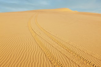 All-terrain vehicle (ATV) tracks in white sand dunes on sunrise, Mui Ne, Vietnam. Dunes around Bao