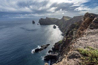 Red cliffs and rocks in the sea, coastal landscape with dramatic sky, Ponta de São Lourenço,