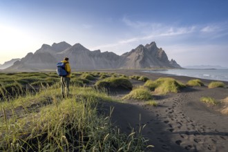 Tourist on a sand dune, Black beach with volcanic sand, Sand beach, Dunes with grass, Stokksnes