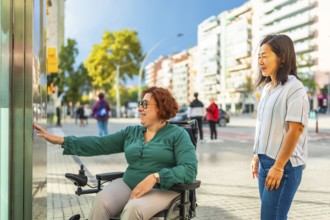 Disabled woman in a wheelchair and Asian friend waiting for the public transport elevator