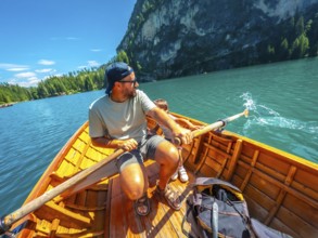 Tourists enjoying a sunny day rowing on the famous lake braies, surrounded by the stunning