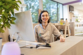 Cheerful young caucasian saleswoman smiling at camera while working on the counter of a pharmacy