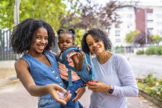 Portrait of three generation african female family in the park smiling at camera standing together