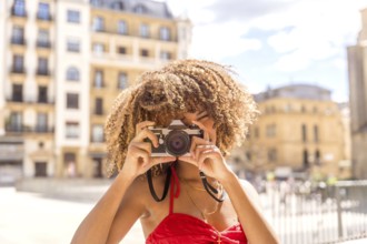 Cute cool and beauty brunette woman taking a photo and smiling visiting a city