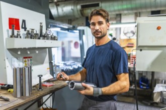 Portrait of a young operator working in metal pieces in a factory