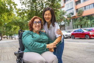 Portrait of a happy caucasian adult woman with disability sitting on electric wheelchair and her