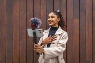 African american beauty woman vlogger smiling recording a new video blog in the city