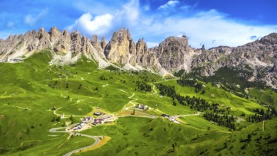 Stunning aerial view of the picturesque gardena pass winding through lush green valleys, embraced