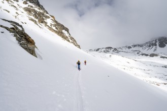 Two ski tourers in a wintry mountain landscape, ascent to Piz Laviner, Grisons Haute Route, Albula