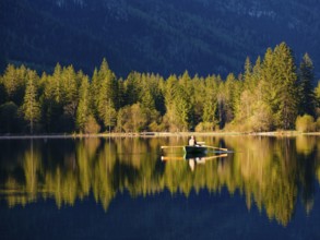 Angler in a rowing boat on the Hintersee in the first sunlight, Berchtesgaden National Park,