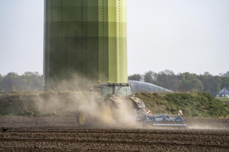 A tractor works a field, due to long dryness in spring, no rain for more than 4 weeks, the fields
