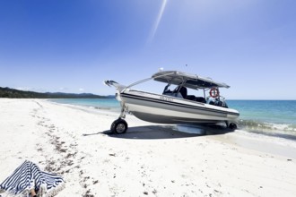 Boat on wheels standing at unique famous Whitehaven Beach. Modern amphibious boat capable to drive