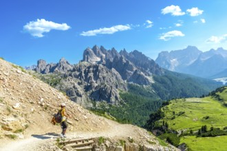 Female tourist hiking on a mountain trail with breathtaking views of the tre cime di lavaredo peaks