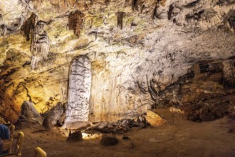 Tourists riding a train admiring the illuminated stalagmites and stalactites inside the famous