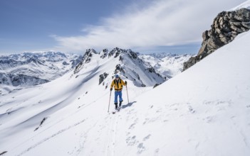 Ski tourer on a mountain ridge, mountain landscape with snow, mountain panorama with summit of the