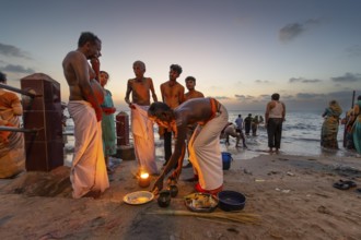 Hindu priest with pilgrims at the fire ritual at Ghat Agni Theertham, Rameswaram, Pamban Island,