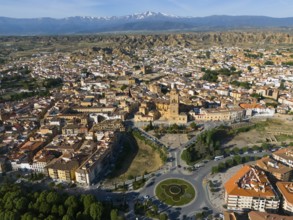Aerial view of a city with historical centre, roundabout and green parks, surrounded by landscape