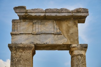Close-up of an ancient stone gate with fine carvings and blue sky in the background, Well house,