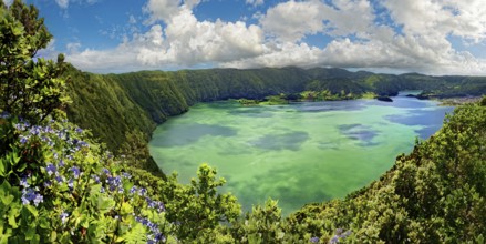 Breathtaking panoramic view of the crater lake Lagoa Azul surrounded by steep rock faces under a