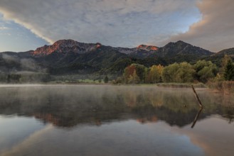 Mountains reflected in lake, morning light, autumn colours, clouds, Lake Kochel, Alpine foothills,