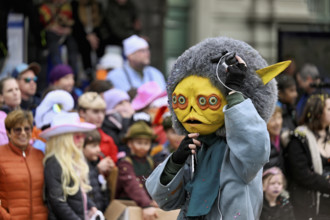 Person masked as an extraterrestrial at the carnival parade of the Wey guild on Rose Monday,
