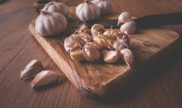 Fresh garlic on a chopping board, wooden table, knife, rustic, mobile photo, no people