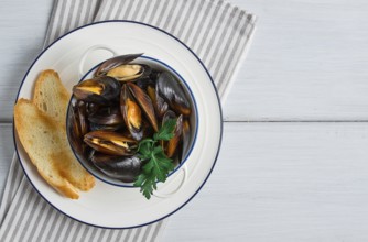 Fresh, Boiled mussels, Black Sea, with white bread, on a white wooden table, no people