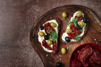 Sandwich with cream cheese, dried tomatoes, olives, breakfast, top view