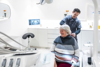 Dentist is preparing a smiling senior woman for a dental checkup in a modern and bright dental