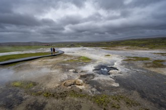 Tourists on a logging road between hot springs, Hveravellir geothermal area, Icelandic Highlands,