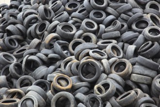 Old car tyres lie on stockpiles for recycling