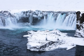 Ice layer in the river Skialfandaljot, behind it the waterfall Godafoss, Northern Iceland Eyestra,